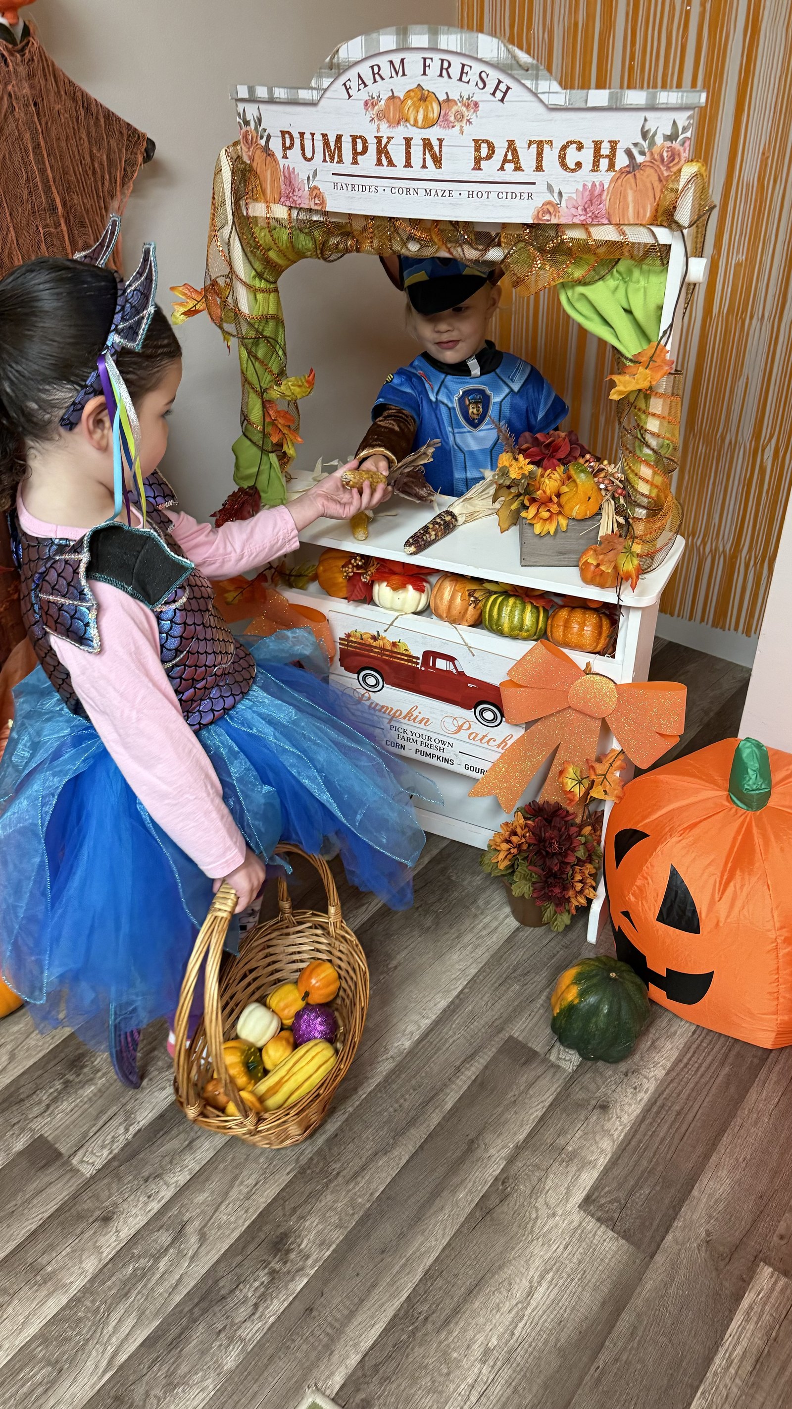 Children playing in a pumpkin patch dramatic play setup